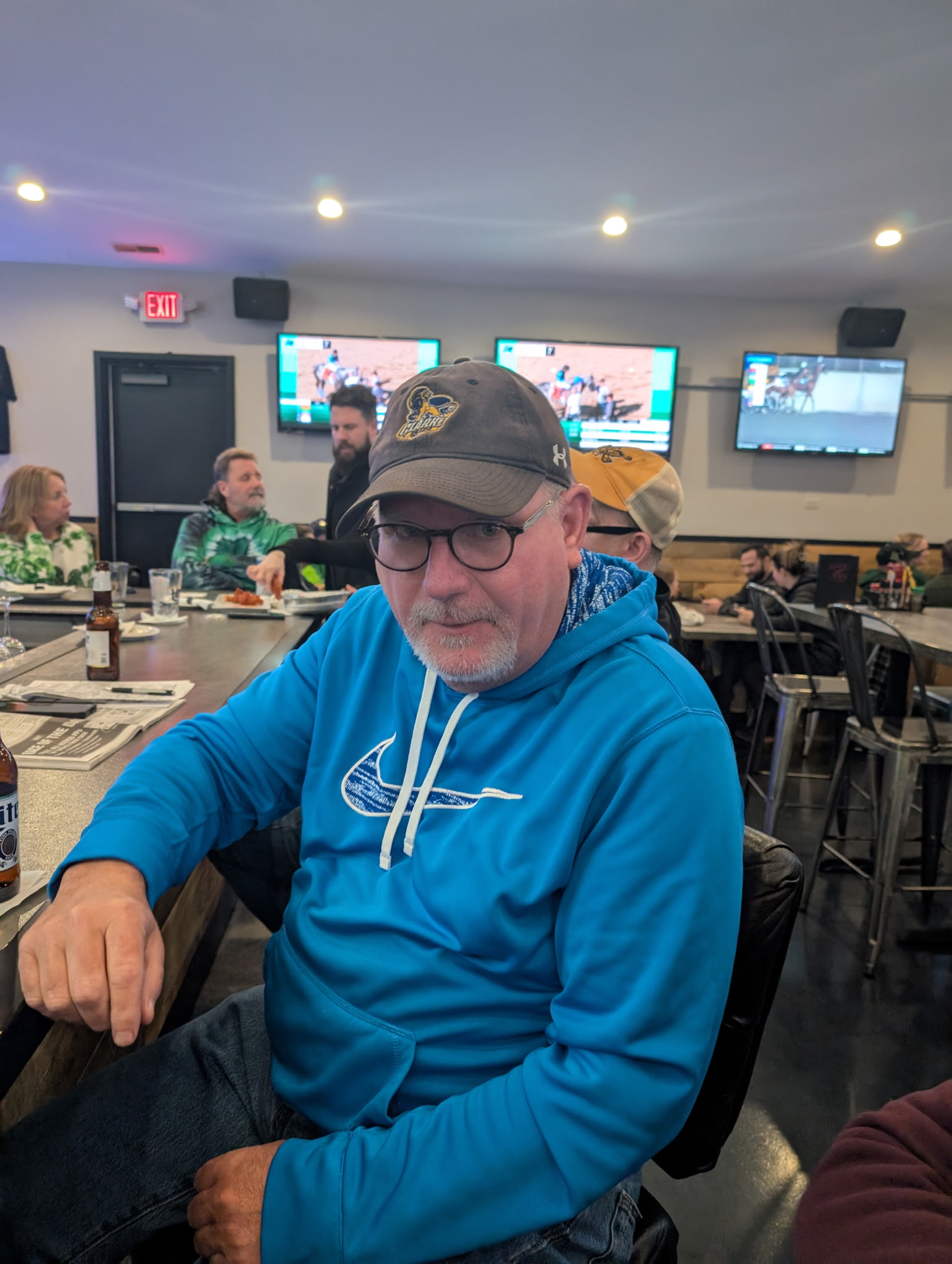 A league memory at a sports bar, with a man in a blue hoodie seated at the table